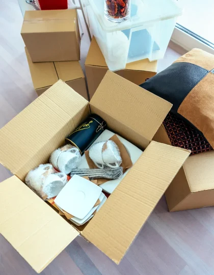 Open boxes with kitchen items on floor.