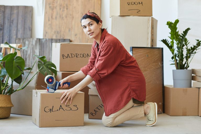 Woman packing boxes for moving house.