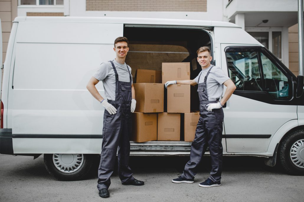 Two movers unloading van with boxes