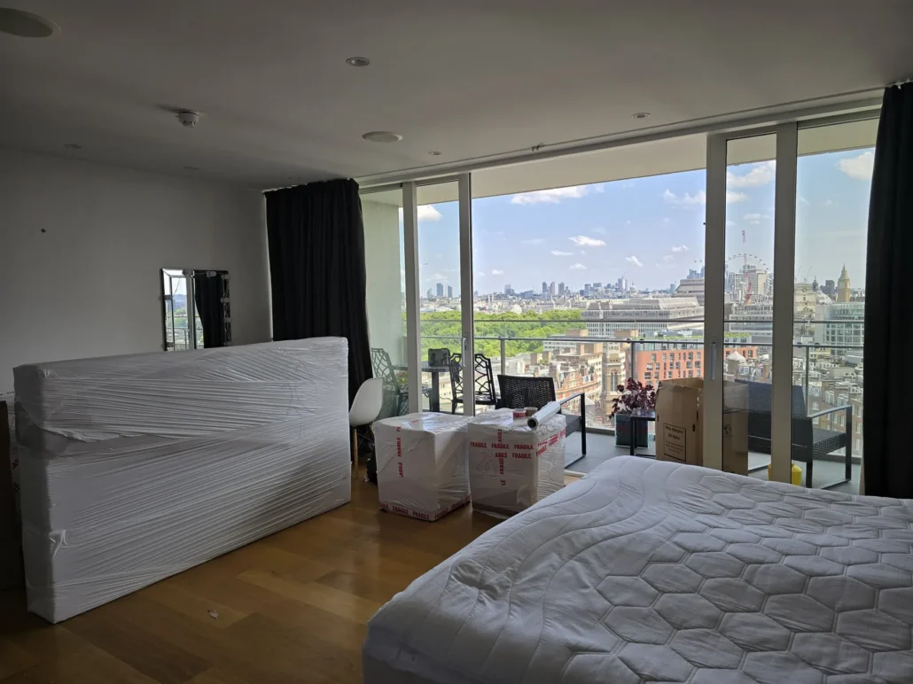 Wrapped furniture ready for a flat move, with a view over London